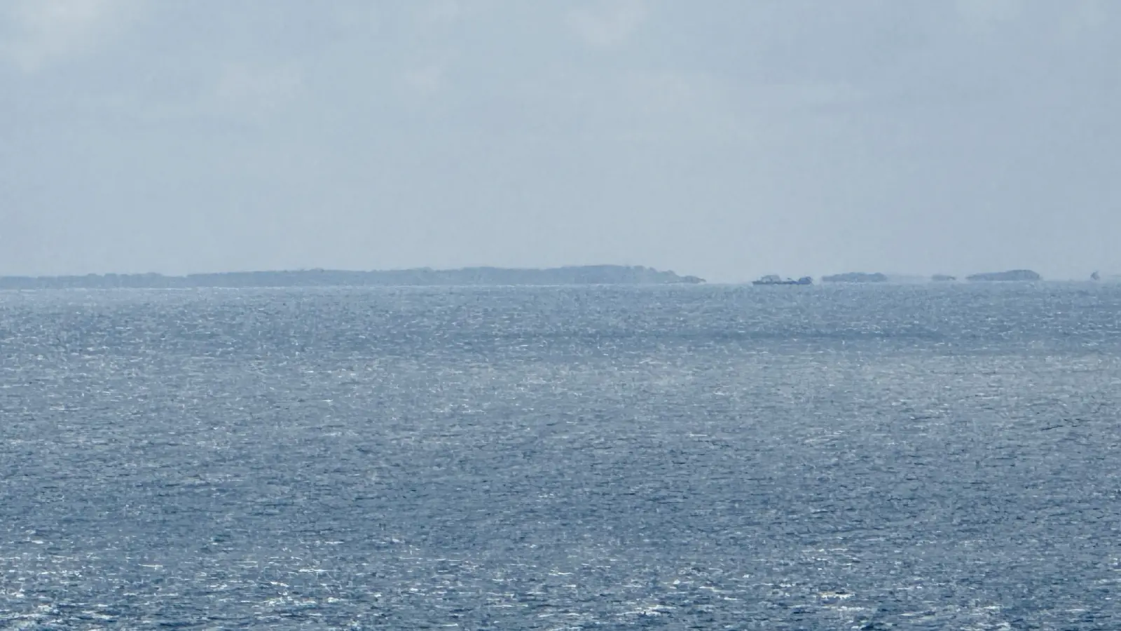 The Isles of Scilly appearing as a faint line of low islands on the Atlantic horizon